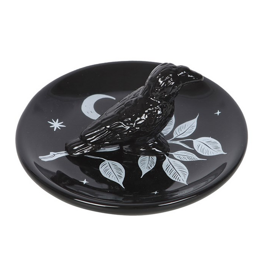 Black decorative plate with white designs on a white background