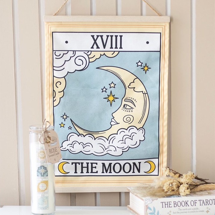 Framed artwork with a moon and star design on a wall.