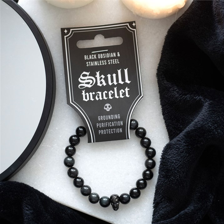 Black skull bracelet on a white surface with packaging label