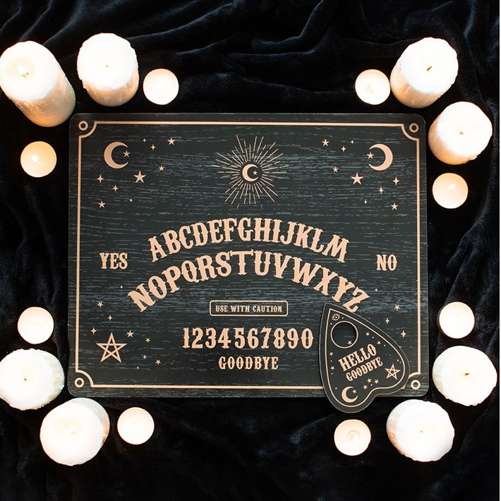 Ouija board with candles on a dark background