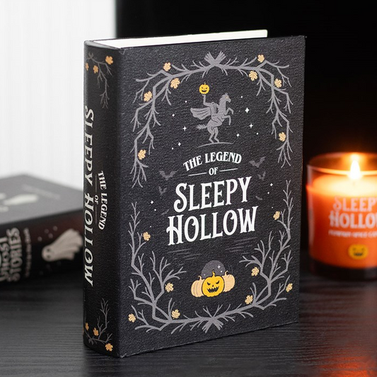 Book titled 'The Legend of Sleepy Hollow' with decorative cover and candle in the background