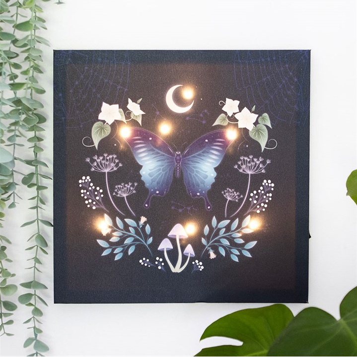 Decorative wall art with a butterfly design on a dark background, surrounded by green leaves.