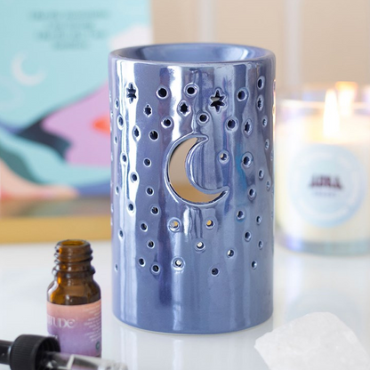 Blue ceramic diffuser with moon design on a blurred background