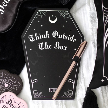 Notebook with 'Think Outside The Box' text and a pen on a decorative background