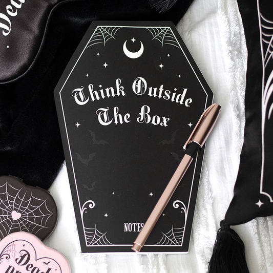 Notebook with 'Think Outside The Box' text and a pen on a decorative background