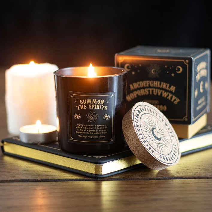 Candle with packaging and decorative items on a wooden surface