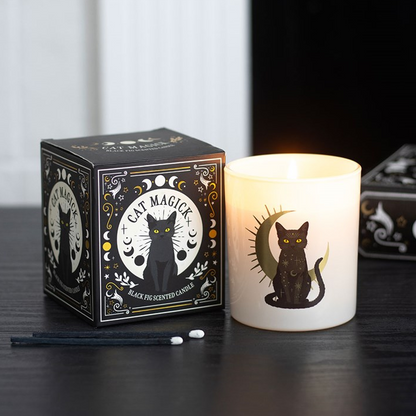 Candle and packaging with cat design on a dark surface