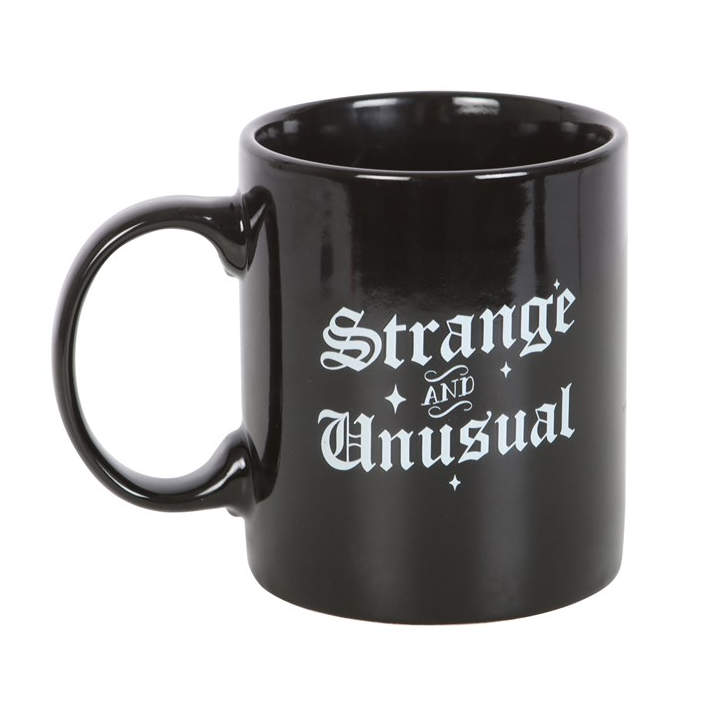 Black mug with 'Strange and Unusual' text on a white background