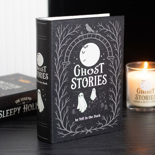 Book titled 'Ghost Stories to Tell in the Dark' with a candle in the background