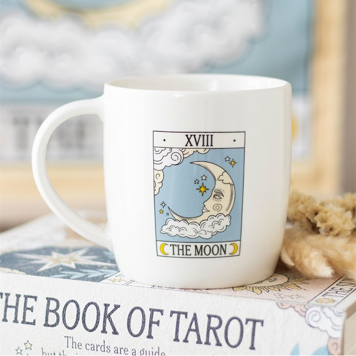 White mug with 'The Moon' tarot card design on a book titled 'The Book of Tarot'.