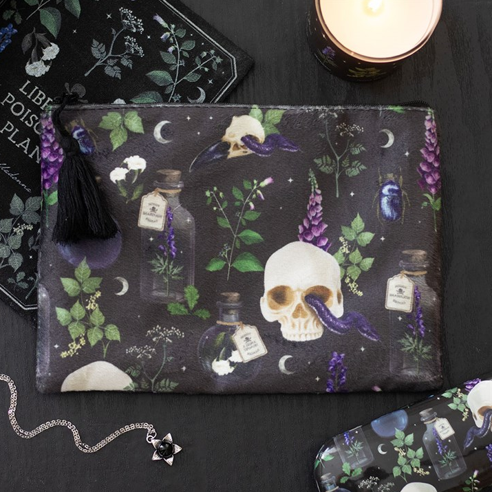 Dark pouch with skull and potion bottle design on a black surface