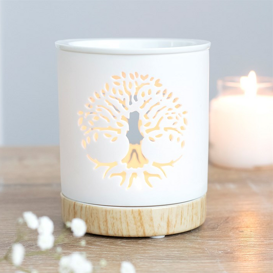 Ceramic wax warmer with decorative cutout on a wooden surface