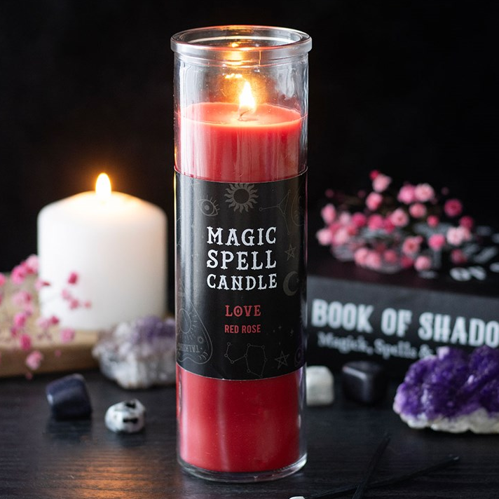 Red spell candle with a black label on a dark background