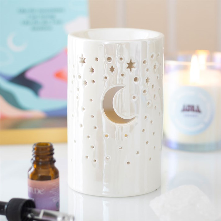 Decorative candle holder with moon and star design on a white surface.