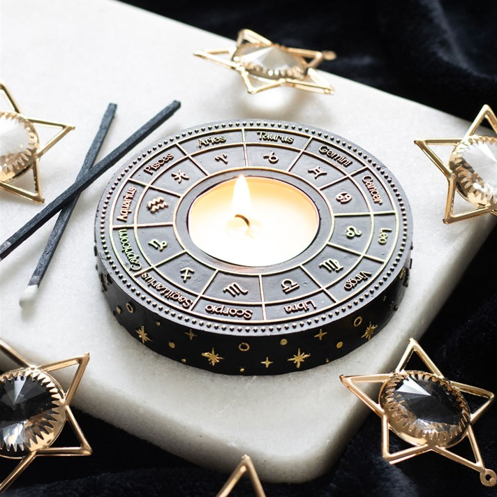 Decorative candle holder with zodiac symbols on a marble surface