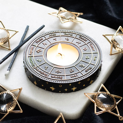 Decorative candle holder with zodiac symbols on a marble surface