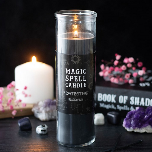 Magic spell candle labeled 'Protection' with decorative items on a dark surface