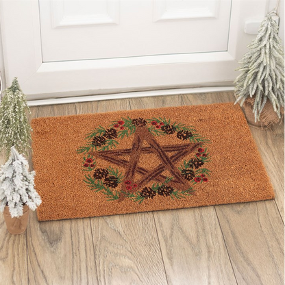 Doormat with pentacle design on a wooden floor in front of a white door.