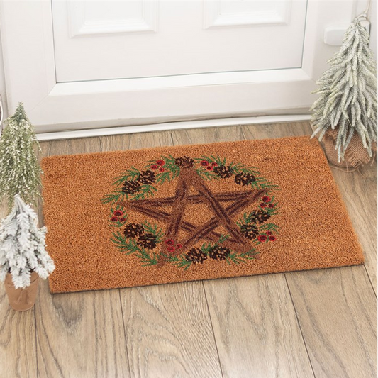 Doormat with pentacle design on a wooden floor in front of a white door.