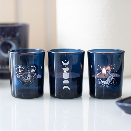 Three blue glass tumblers with decorative designs on a white surface.