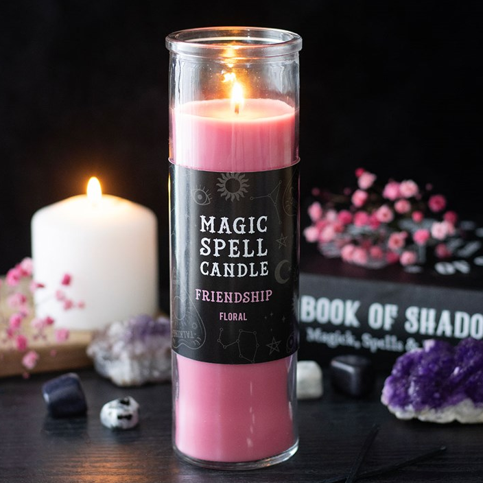 Pink spell candle labeled 'Magic Spell Candle' with a dark label on a mystical setting.