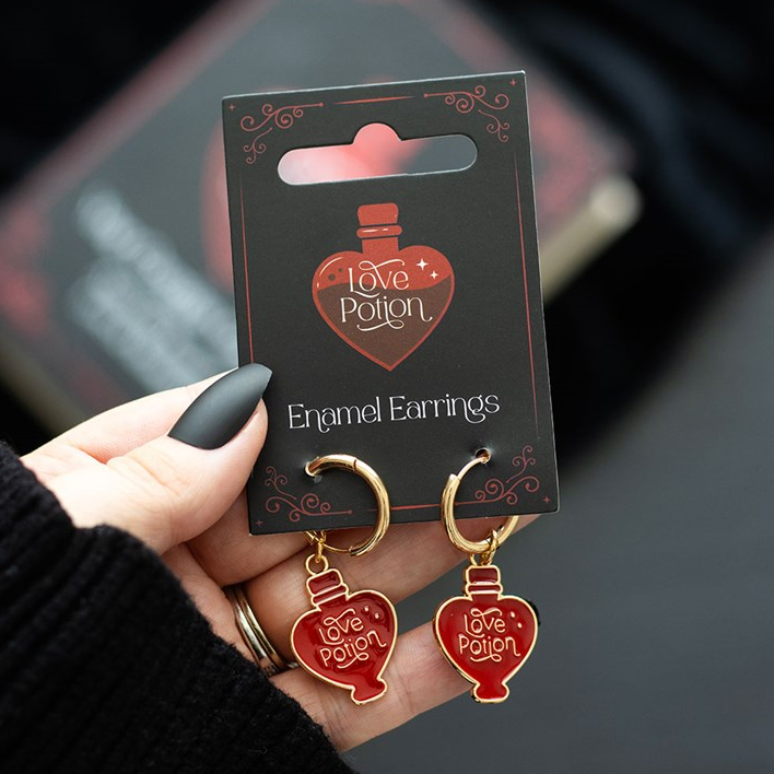 Engel earrings on a 'Love Potion' branded card held by a hand.