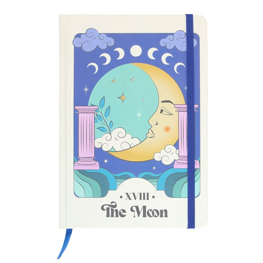 Notebook with a celestial design on the cover, featuring a moon face and astrological symbols.