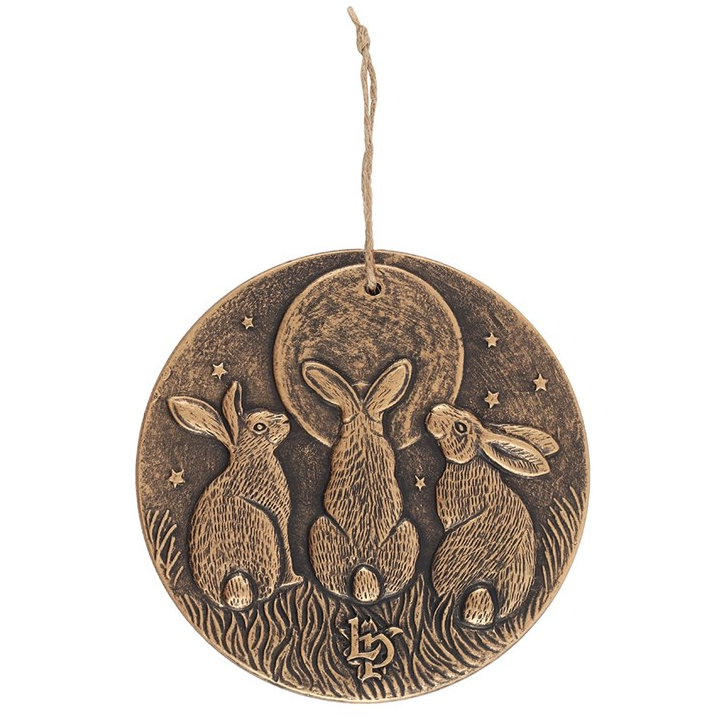 Decorative hanging disc with three rabbits and a moon on a white background