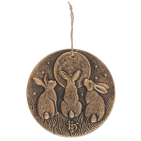 Decorative hanging disc with three rabbits and a moon on a white background