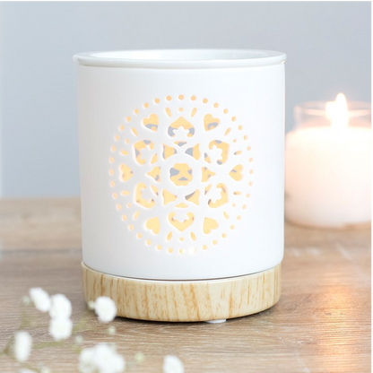 White ceramic candle holder with wooden base on a wooden surface