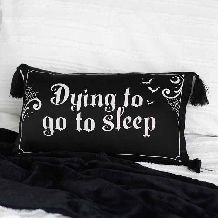 Black pillow with 'Dying to go to sleep' text on a white background