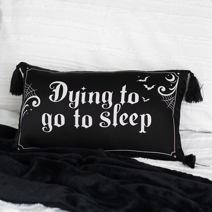 Black pillow with 'Dying to go to sleep' text on a white background