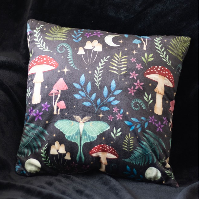 Decorative pillow with fairy tale design featuring mushrooms and fairies on a dark background