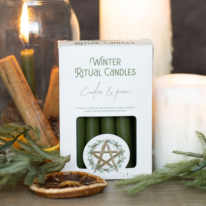 Box of winter ritual candles with decorative elements on a white background