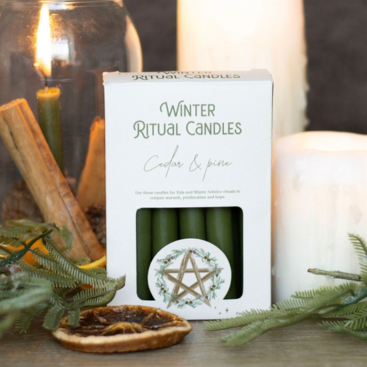 Box of winter ritual candles with decorative elements on a white background