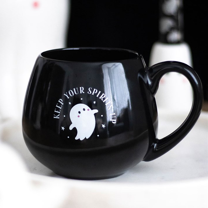 Black mug with ghost design and text on a white background