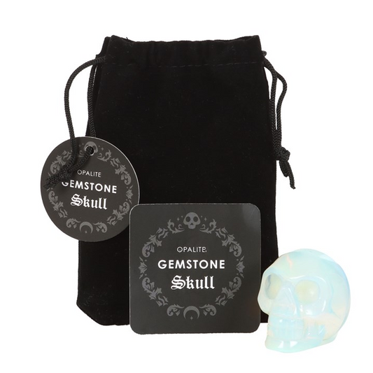 Gemstone skull with packaging and black drawstring bag on a white background