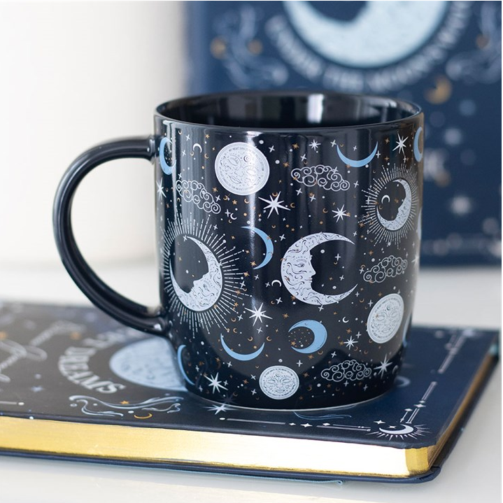 Black mug with celestial design on a white surface