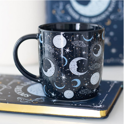 Black mug with celestial design on a white surface