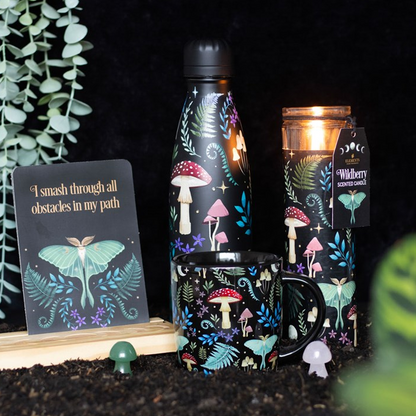 Set of mushrooms-themed products including a bottle, mug, and candle on a dark background.
