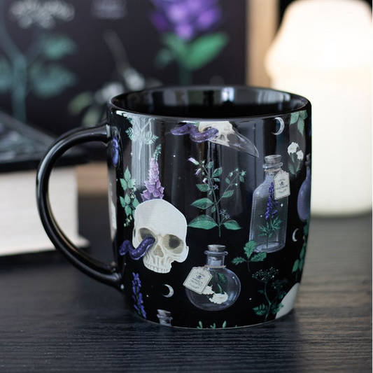 Black mug with skull and potion bottle design on a dark background
