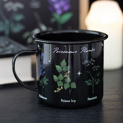 Black mug with botanical illustrations and text on a dark surface