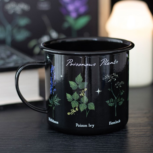 Black mug with botanical illustrations and text on a dark surface