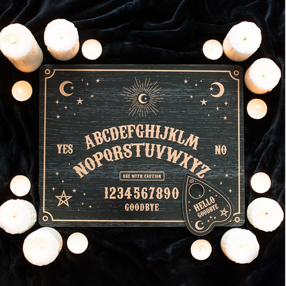 Ouija board with candles on a dark background
