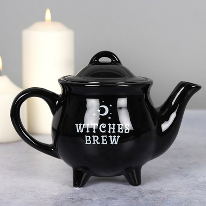 Black teapot with 'Witches Brew' text on a gray background