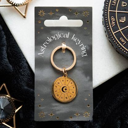 Gold astrological keyring on a branded card with a white background