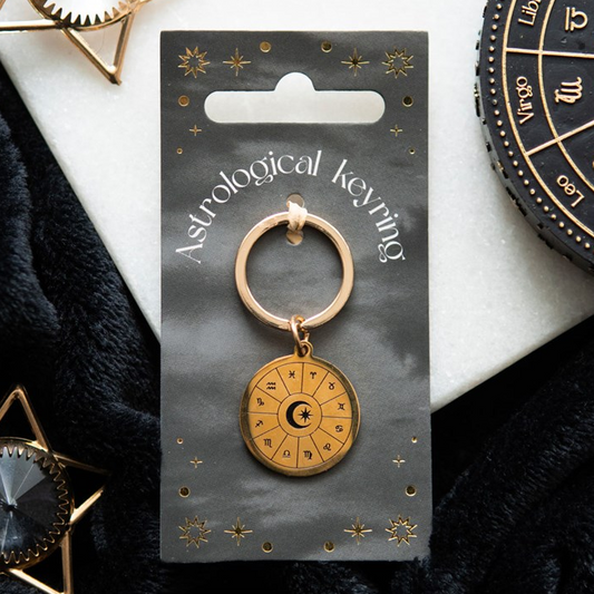 Gold astrological keyring on a branded card with a white background