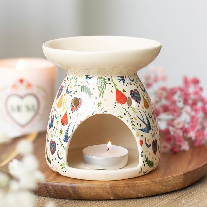 Decorative wax warmer with floral design on a wooden base
