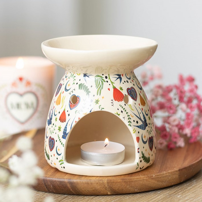 Decorative wax warmer with floral design on a wooden base